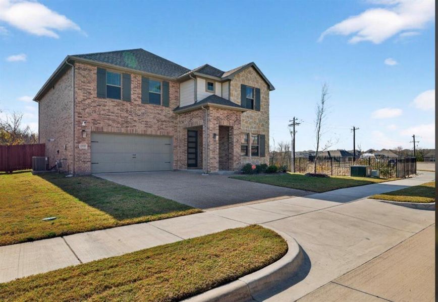 View of front of home featuring concrete driveway, a garage, and brick siding