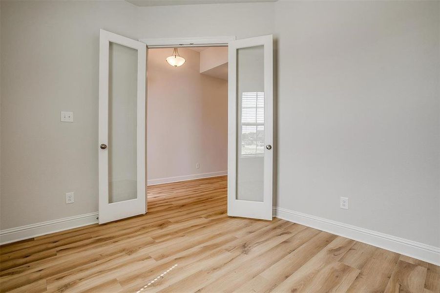 Empty room featuring light hardwood / wood-style floors and french doors