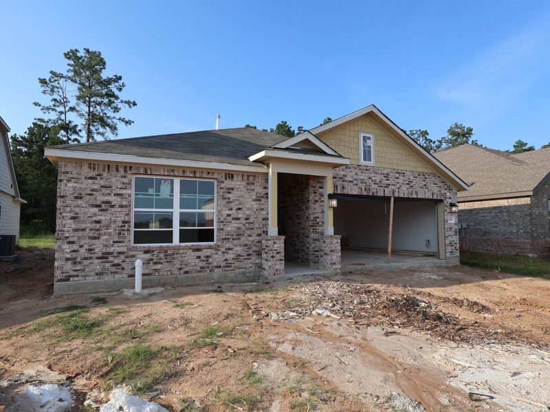 Front exterior of a new home in Pinewood at Grand Texas, New Caney, TX, highlighting curb appeal (Image 16).