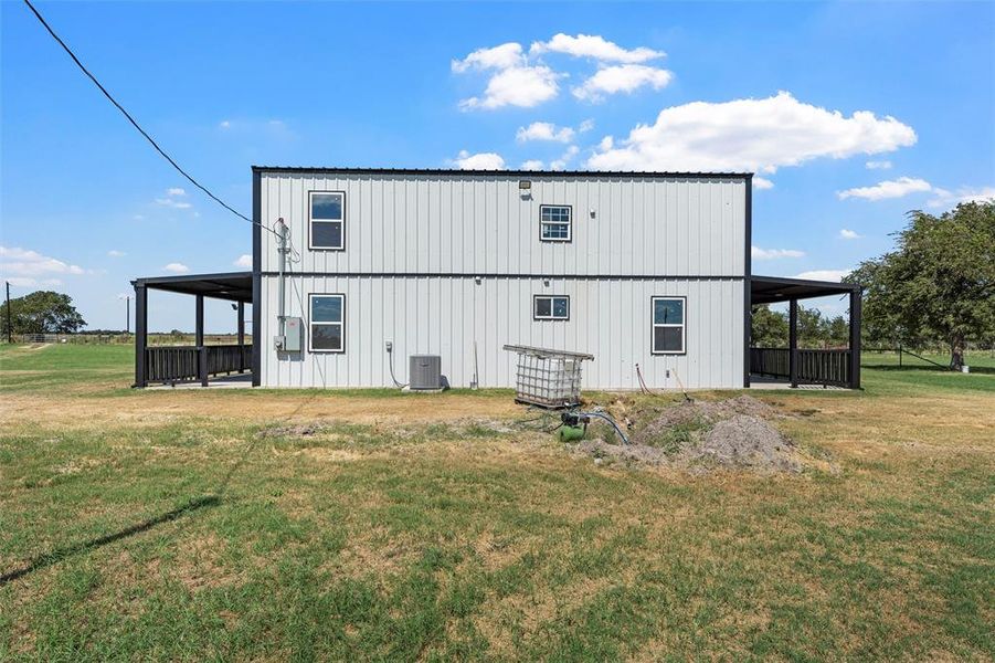 Rear view of property featuring a yard, board and batten siding, and a patio area Rear view of property featuring a yard, board and batten siding, and a patio area