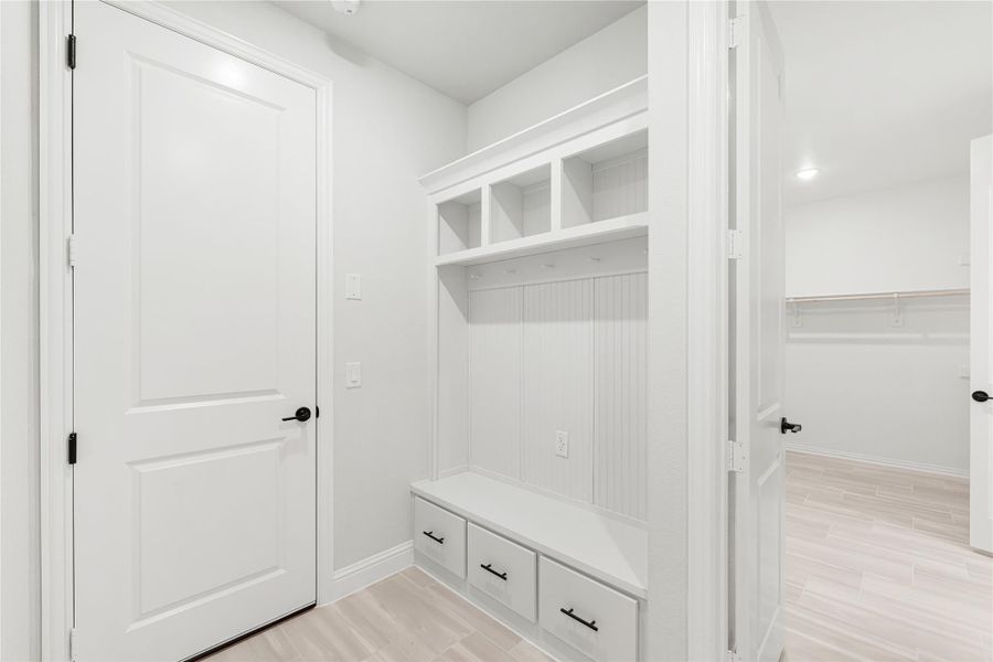 Mudroom with built-in white cubbies, coat hooks, bench, and three storage drawers Mudroom with built-in white cubbies, coat hooks, bench, and three storage drawers