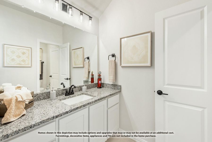 Bathroom with double vanity, granite countertops, white cabinets, and large mirror with overhead lighting Bathroom with double vanity, granite countertops, white cabinets, and large mirror with overhead lighting