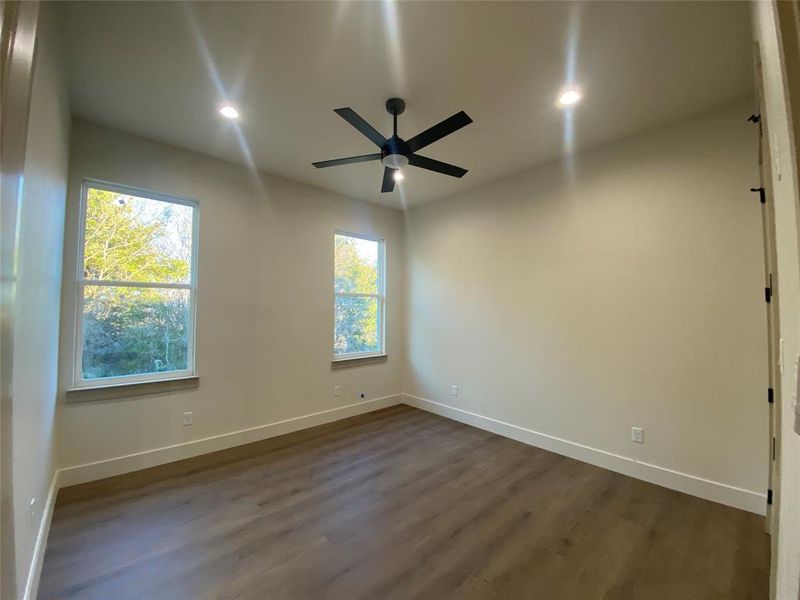 Empty room featuring dark hardwood / wood-style flooring and ceiling fan