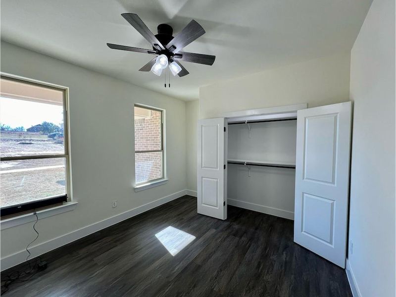 Bedroom/Office hardwood / wood-style floors, multiple windows, and a closet