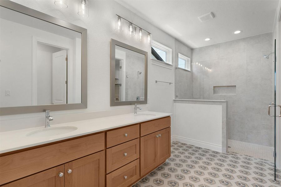 Dual vanity with light wood-finish cabinetry and white countertops