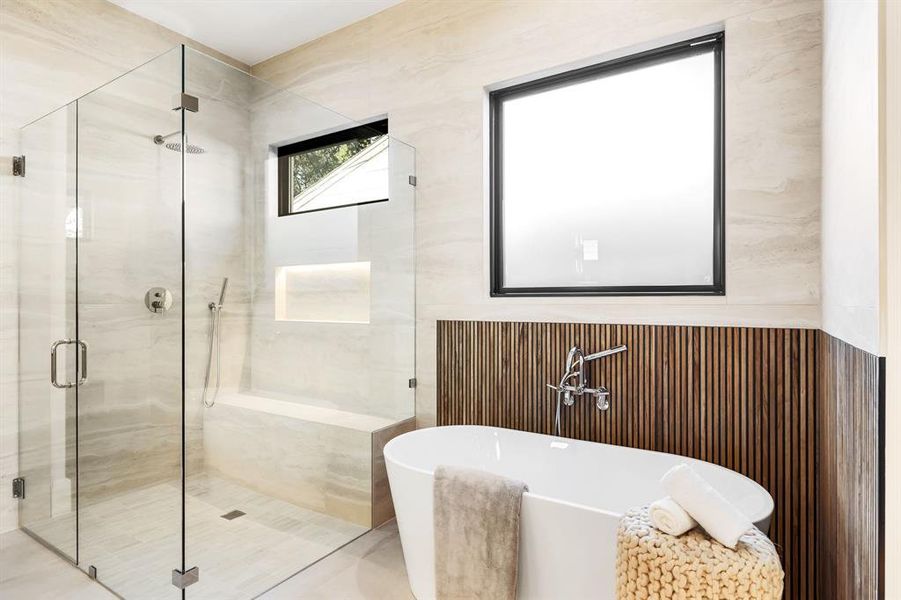Bathroom featuring a soaking tub, a stall shower, and tile walls Bathroom featuring a soaking tub, a stall shower, and tile walls