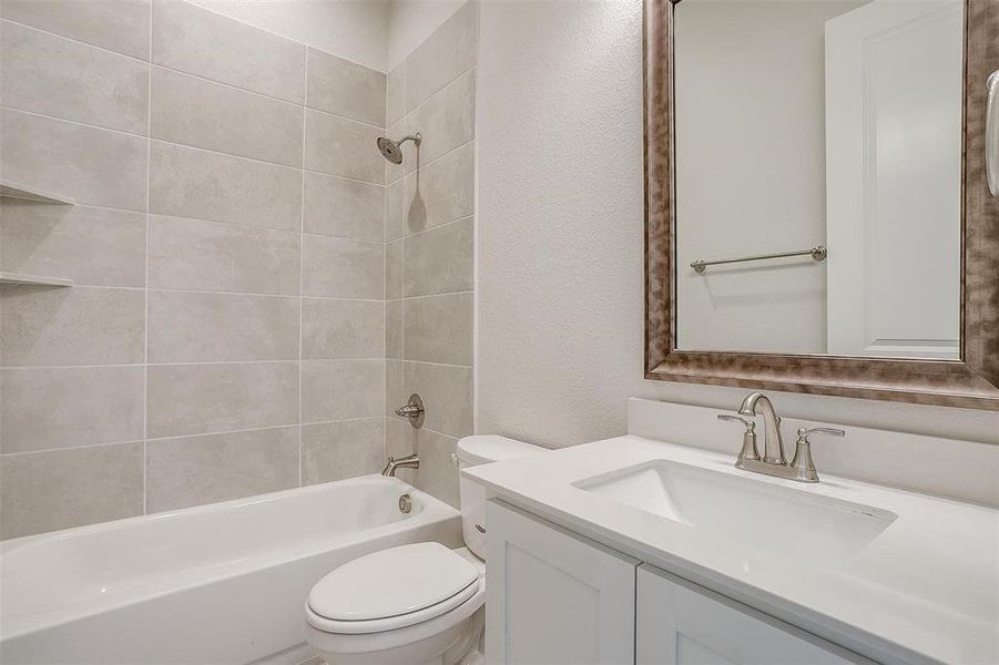 Full bathroom with tiled shower / bath, vanity, and toilet