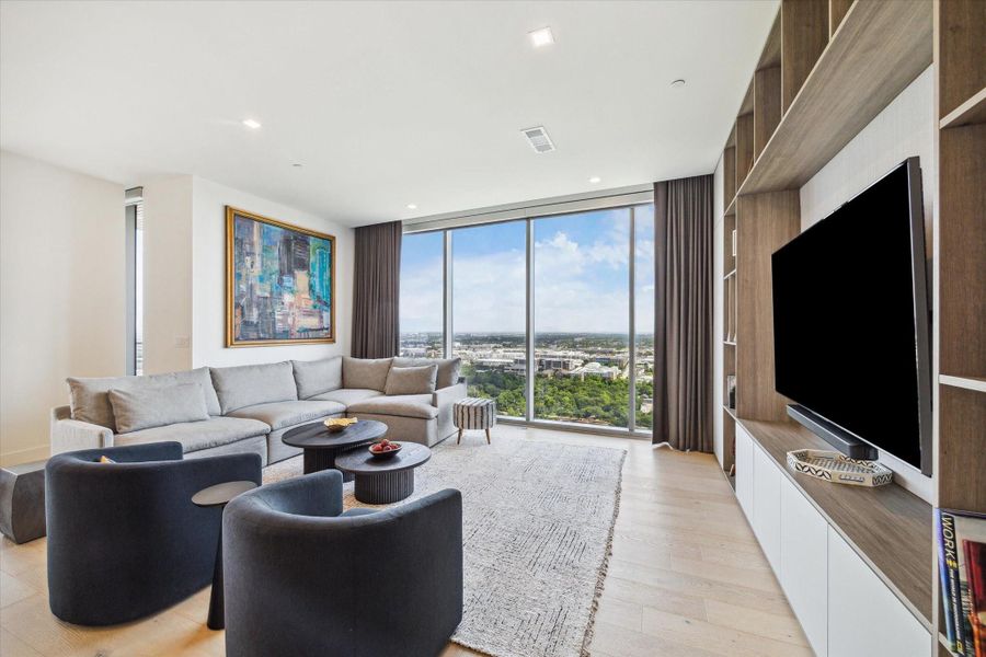 Custom built-in shelves, cabinets, and mounted TV complement the living room.