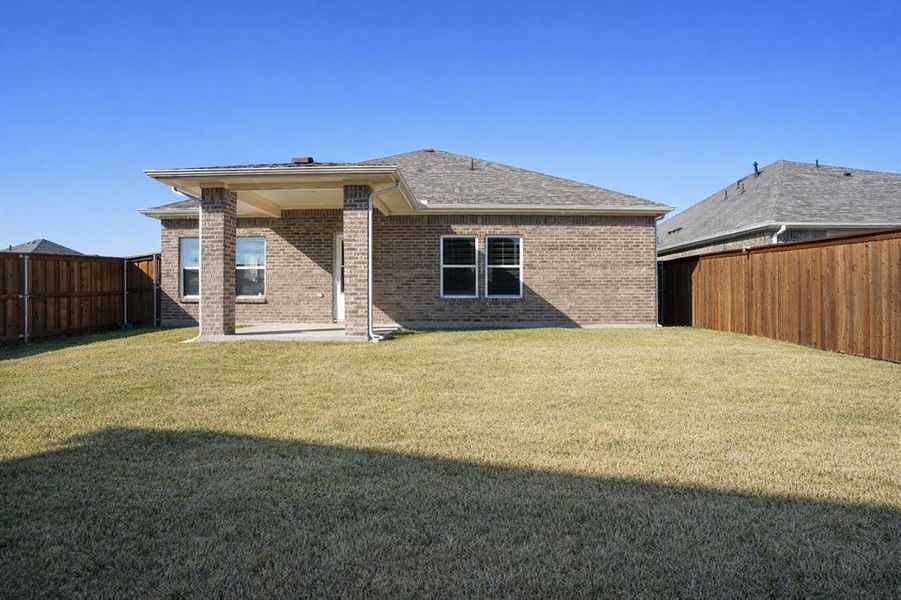 Rear view of property with a patio, brick siding, and a fenced backyard