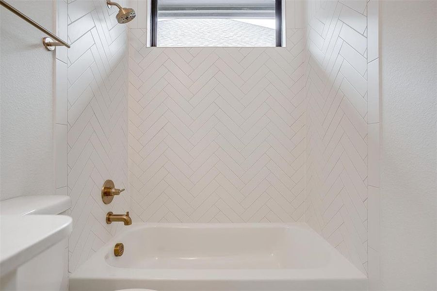 Bathroom featuring toilet and tiled shower / bath combo