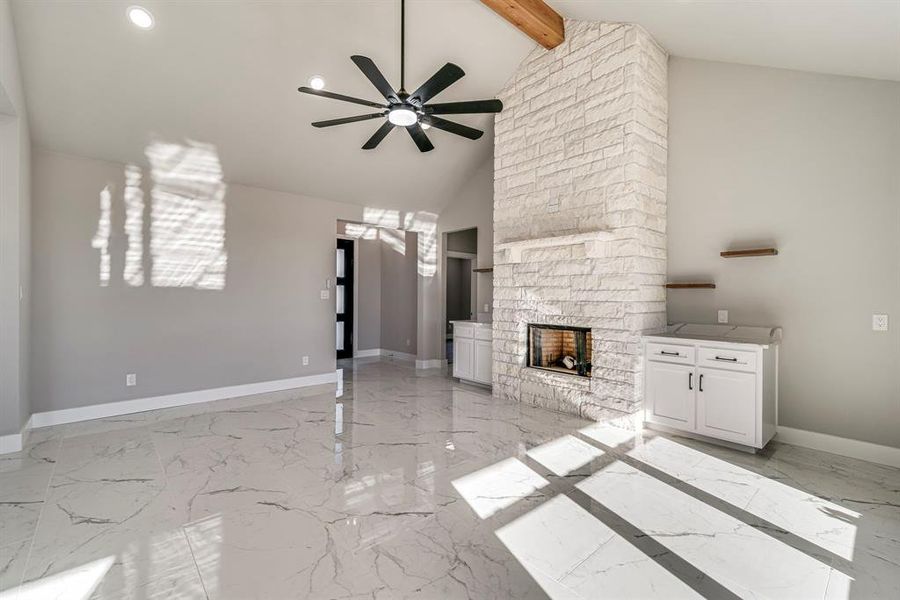 Unfurnished living room with marble finish floor, a fireplace, baseboards, and ceiling fan