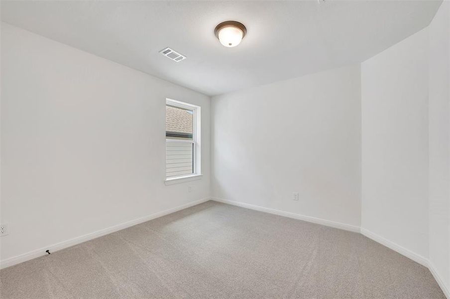 Bright room featuring light gray carpeting, white walls, and a single window