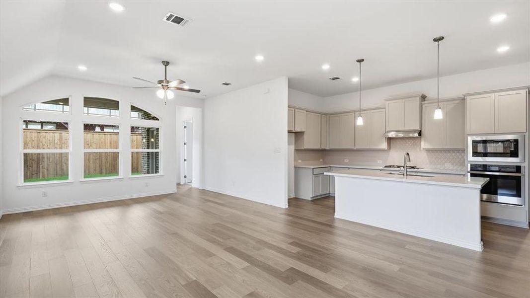 Open-concept living space featuring wood-finish flooring, recessed lighting, and a contemporary ceiling fan Open-concept living space featuring wood-finish flooring, recessed lighting, and a contemporary ceiling fan