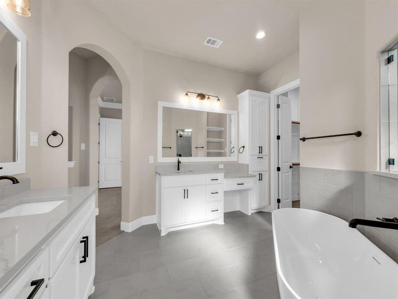 Bathroom with vanity, tile patterned floors, and a bathing tub