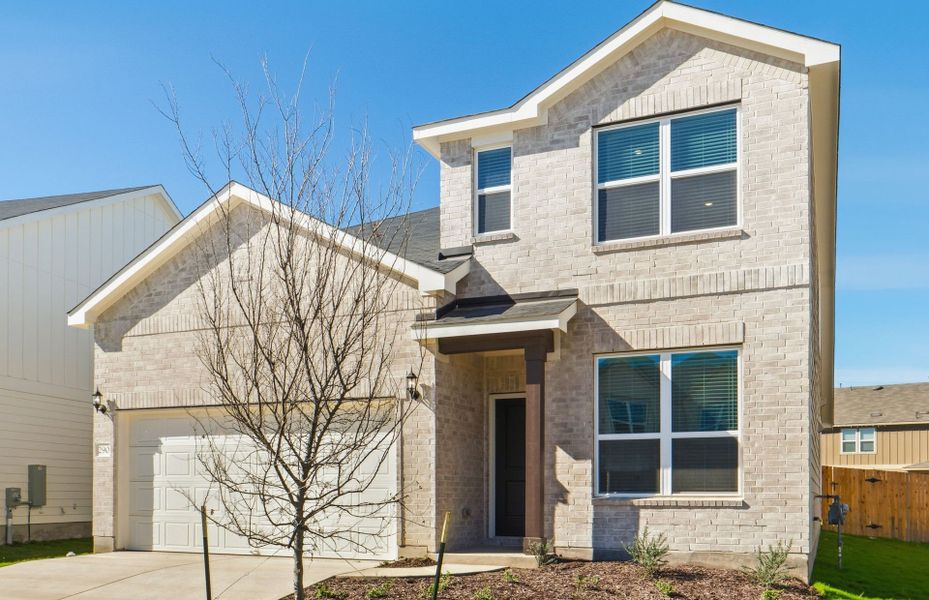 Front exterior of a new home in Sunfield, Buda, TX, highlighting curb appeal (Image 22). Front exterior of a new home in Sunfield, Buda, TX, highlighting curb appeal (Image 22).