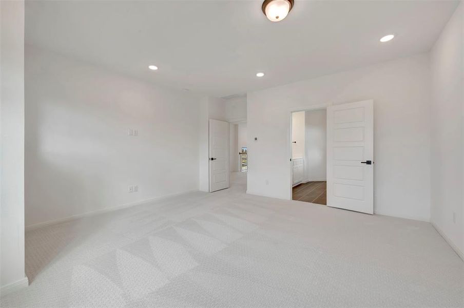 Unfurnished bedroom featuring recessed lighting, light colored carpet, and ensuite bathroom
