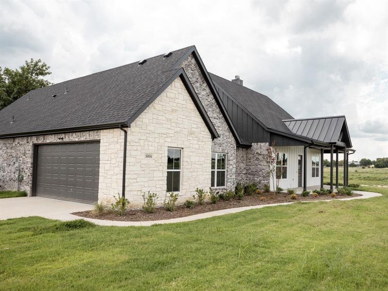 View of front of house featuring stone siding, board and batten siding, a front yard, a chimney, and concrete driveway View of front of house featuring stone siding, board and batten siding, a front yard, a chimney, and concrete driveway