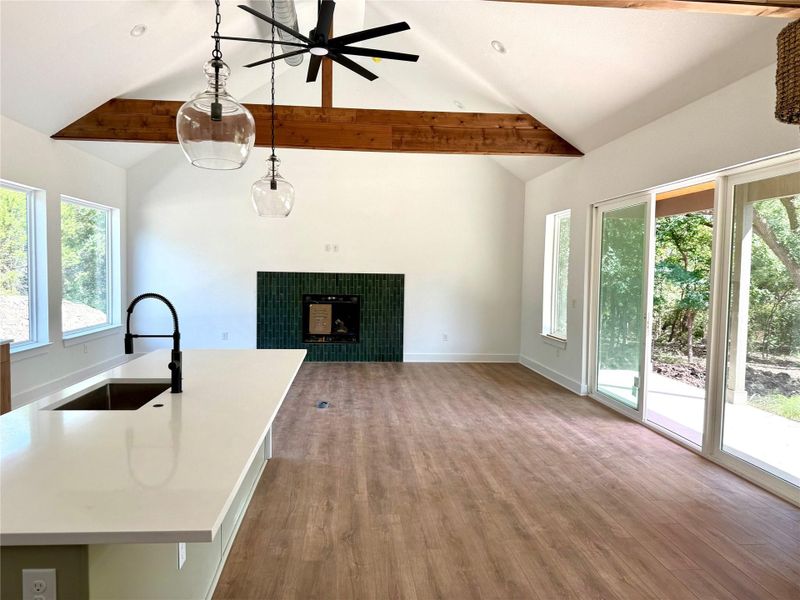 Unfurnished living room featuring plenty of natural light, wood finished floors, beam ceiling, and high vaulted ceiling Unfurnished living room featuring plenty of natural light, wood finished floors, beam ceiling, and high vaulted ceiling