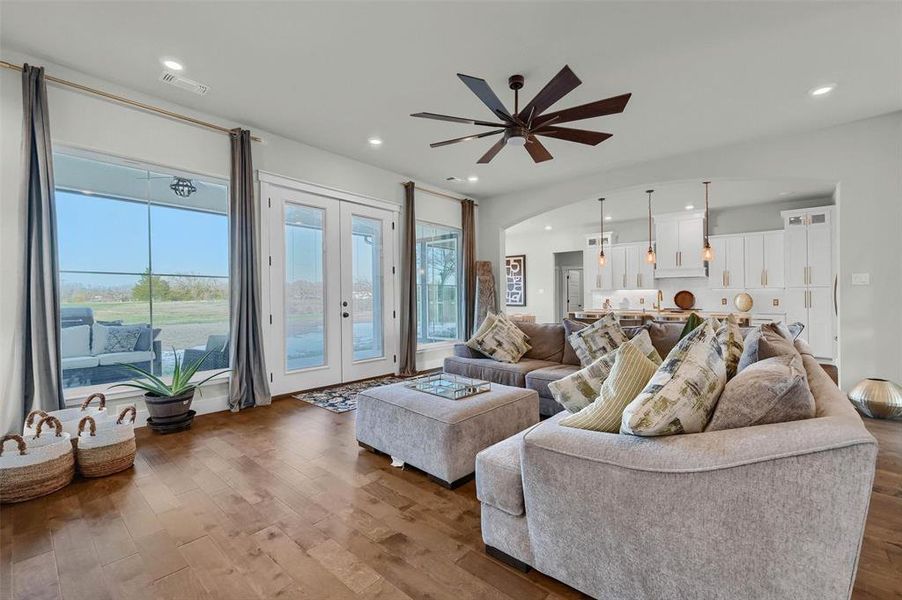 Living room featuring wood-type flooring, ceiling fan, and french doors