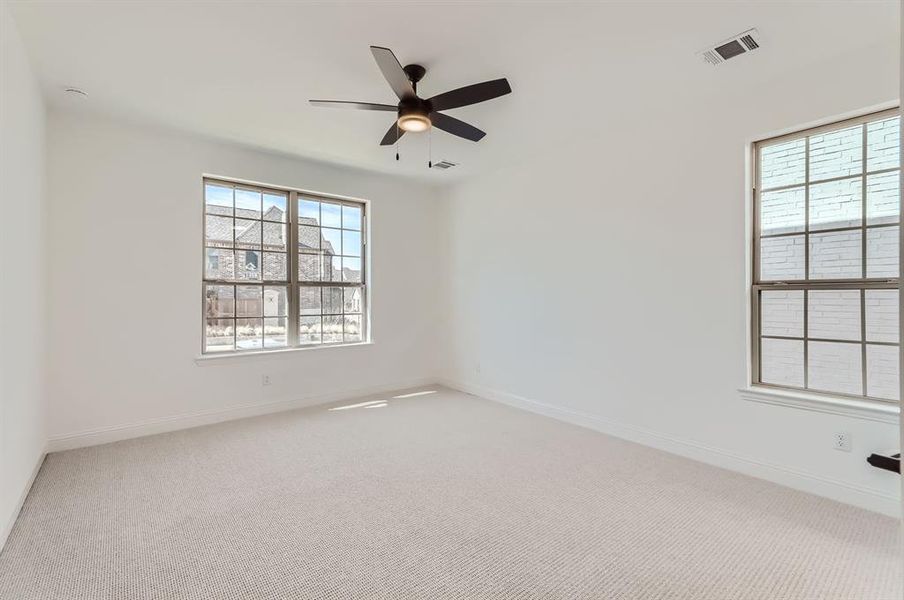 Carpeted spare room featuring ceiling fan