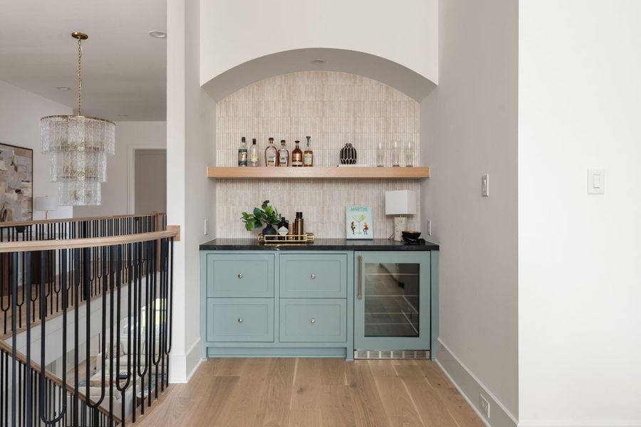 Game room features a bar area with paneled Thermador beverage cooler
