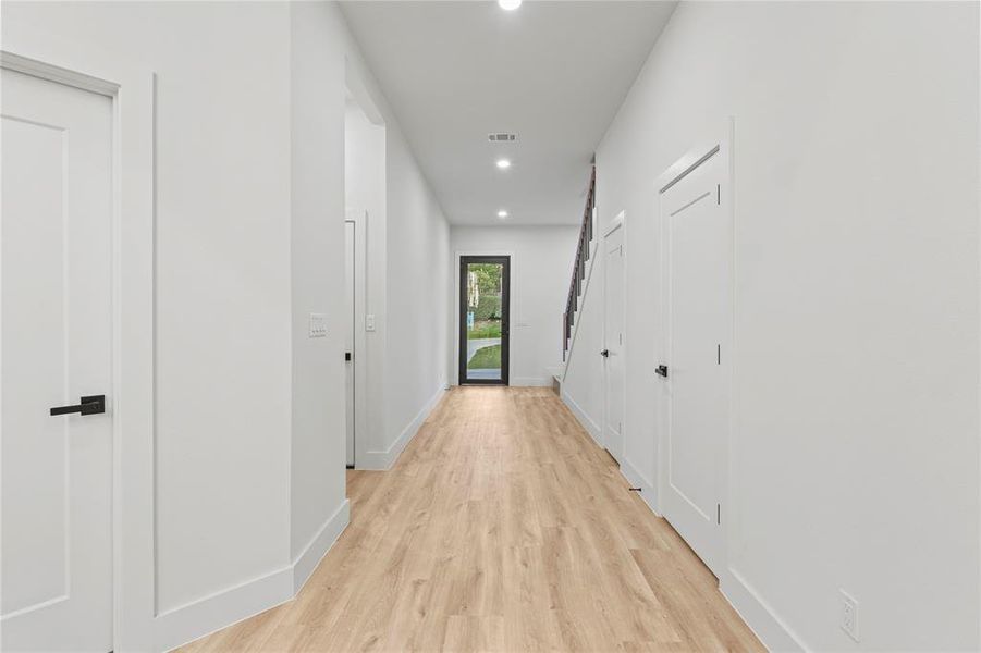 Hallway with light wood-style floors, recessed lighting, and baseboards Hallway with light wood-style floors, recessed lighting, and baseboards
