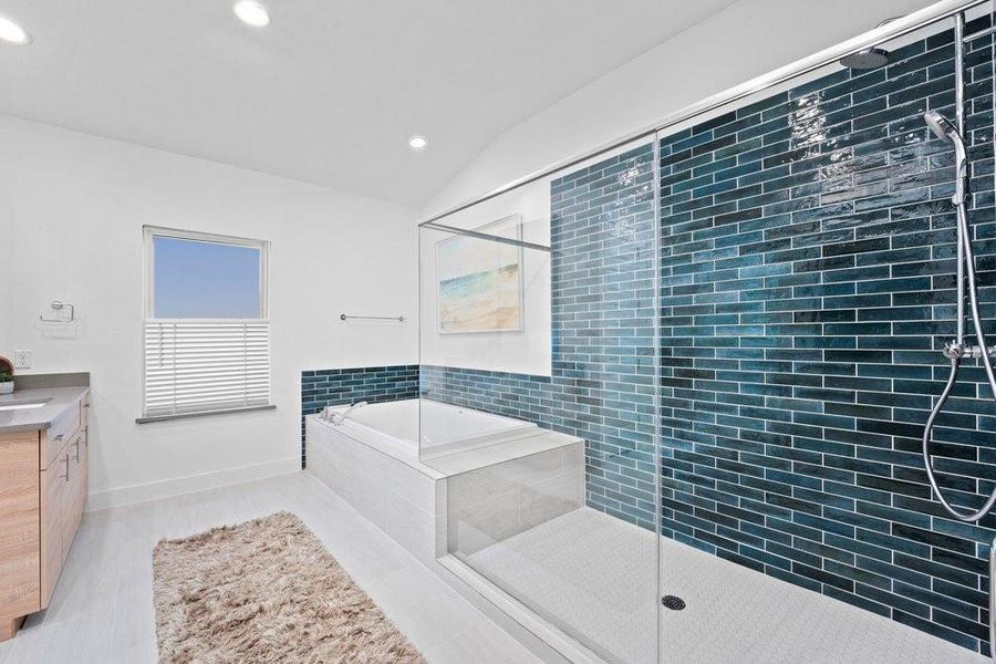 Full bath with tiled shower, a garden tub, vanity, recessed lighting, and lofted ceiling
