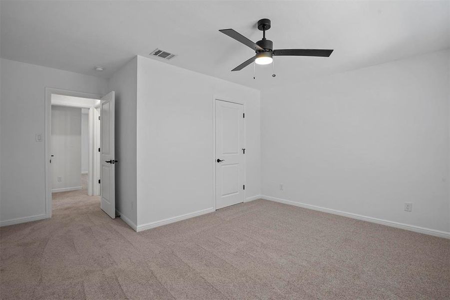 Unfurnished bedroom featuring light carpet and ceiling fan