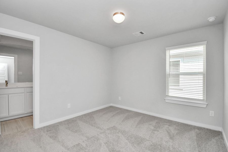 Secondary bedroom features plush carpeting, large windows that let in plenty of natural light, bright paint, and spacious closets.