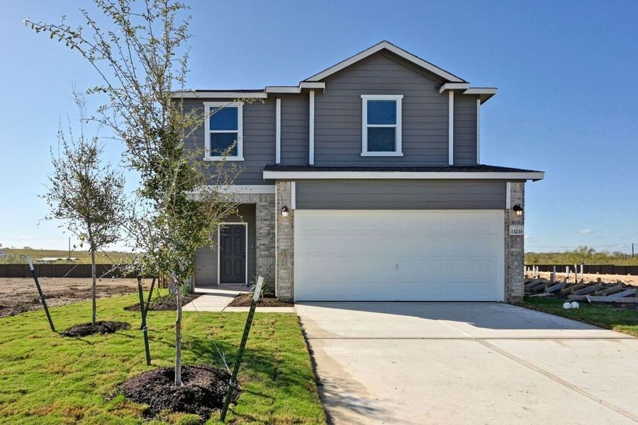 Front exterior of a new home in Stoney Chase, Del Valle, TX, highlighting curb appeal (Image 1). Front exterior of a new home in Stoney Chase, Del Valle, TX, highlighting curb appeal (Image 1).