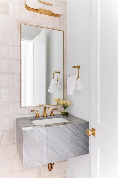 Bathroom with vanity and tasteful backsplash