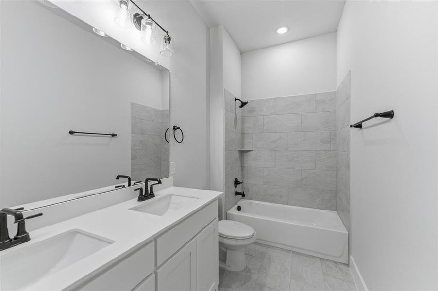 Bathroom featuring double vanity and shower / bathtub combination