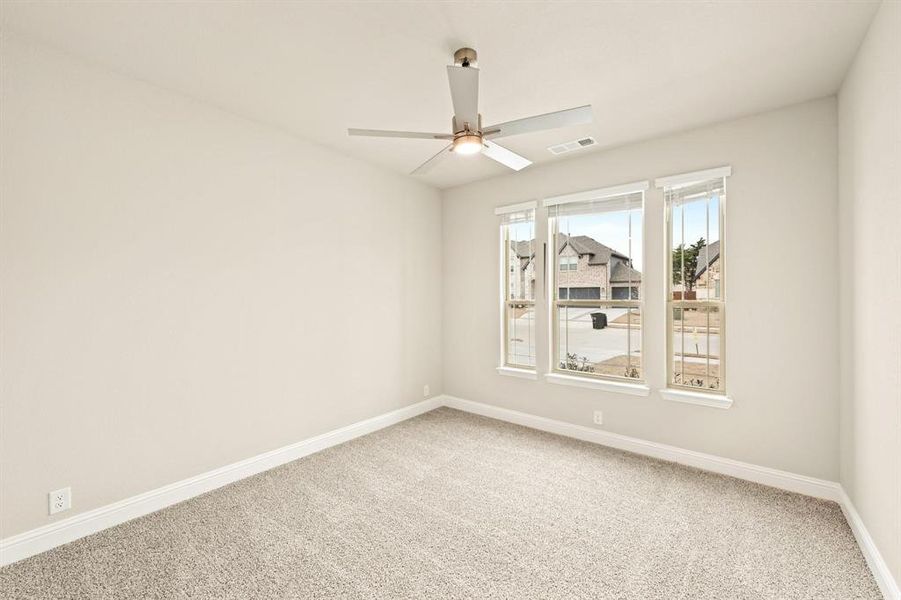 Empty room with carpet flooring and a ceiling fan