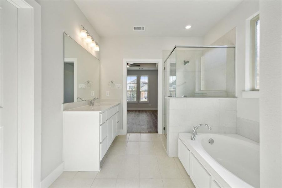 Bathroom with tile patterned flooring, vanity, separate shower and tub, and ceiling fan