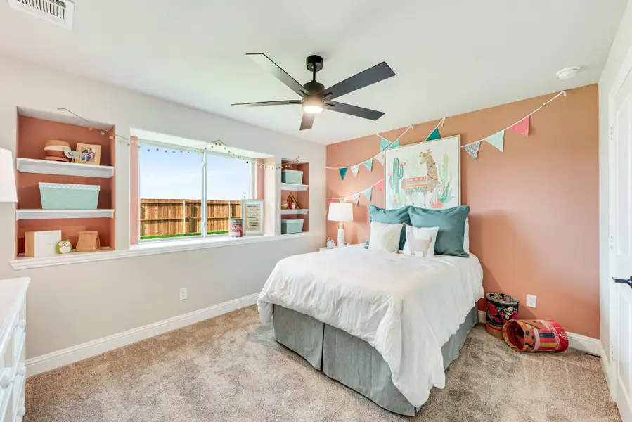Child's bedroom with pink walls, built-in shelves, ceiling fan, and large window