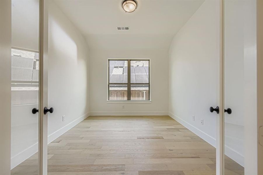 Unfurnished room with french doors and light wood-style flooring