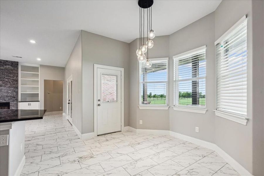 Unfurnished dining area featuring baseboards, marble finish floor, and recessed lighting