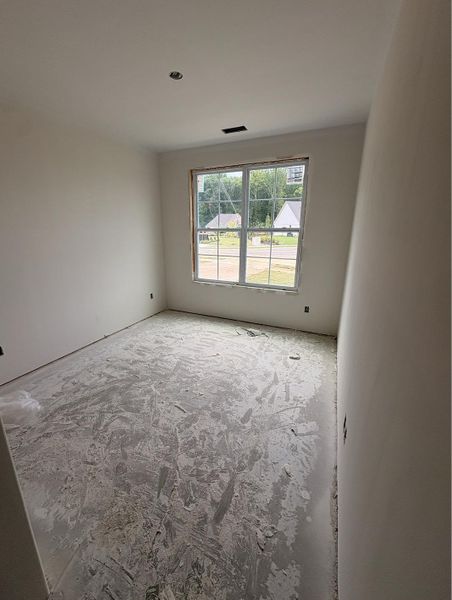 Room featuring a large multi-pane window, white painted walls, and a ceiling-mounted light fixture Room featuring a large multi-pane window, white painted walls, and a ceiling-mounted light fixture