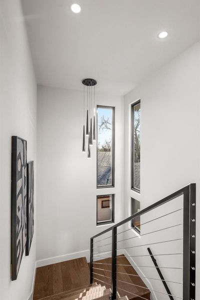 Stairway featuring wood finished floors and recessed lighting