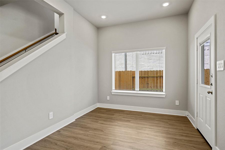 Large windows overlook the backyard, adding warmth and charm to mealtime.