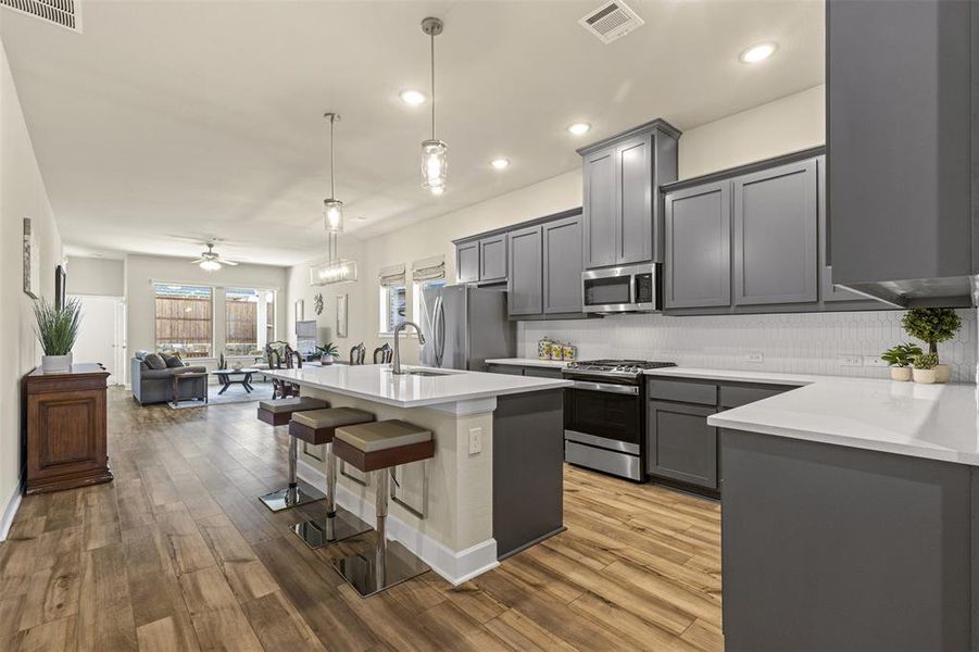 Kitchen with open floor plan, appliances with stainless steel finishes, gray cabinets