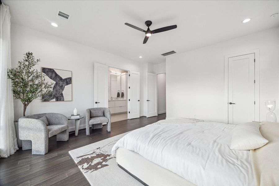 Expansive primary suite filled with natural light and defined by high ceilings and wide-plank flooring. Generous proportions allow for a true retreat experience, with direct access to the spa-inspired bath. Crisp white walls and clean architectural lines create a serene atmosphere designed for relaxation and privacy on the upper level.