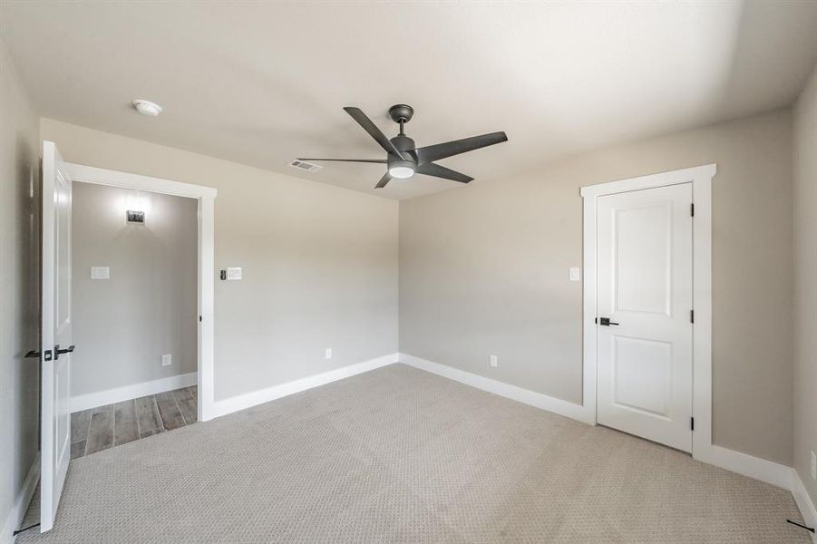 Unfurnished bedroom with carpet floors and ceiling fan Unfurnished bedroom with carpet floors and ceiling fan