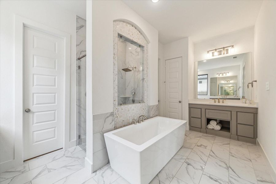 Spa like bathroom with rectanguar soaking tub, modern tile, two sets of vanities , separate shower with glass window, and beautiful tile floors that continue into the shower. Spa like bathroom with rectanguar soaking tub, modern tile, two sets of vanities , separate shower with glass window, and beautiful tile floors that continue into the shower.