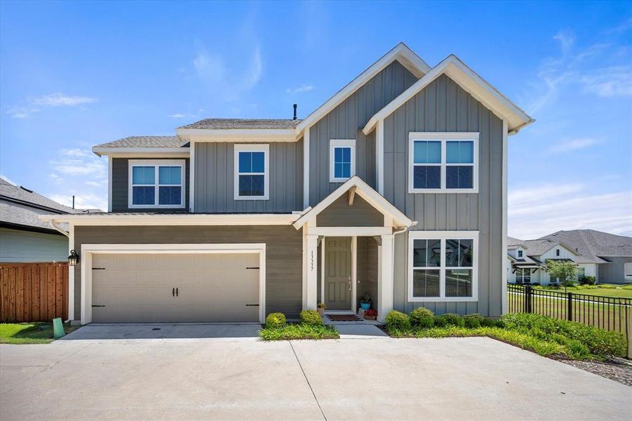 View of front of property with concrete driveway, an attached garage, and board and batten siding View of front of property with concrete driveway, an attached garage, and board and batten siding