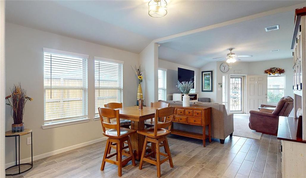 This photo showcases a bright and modern dining area. Large windows provide ample natural light, enhancing the atmosphere.