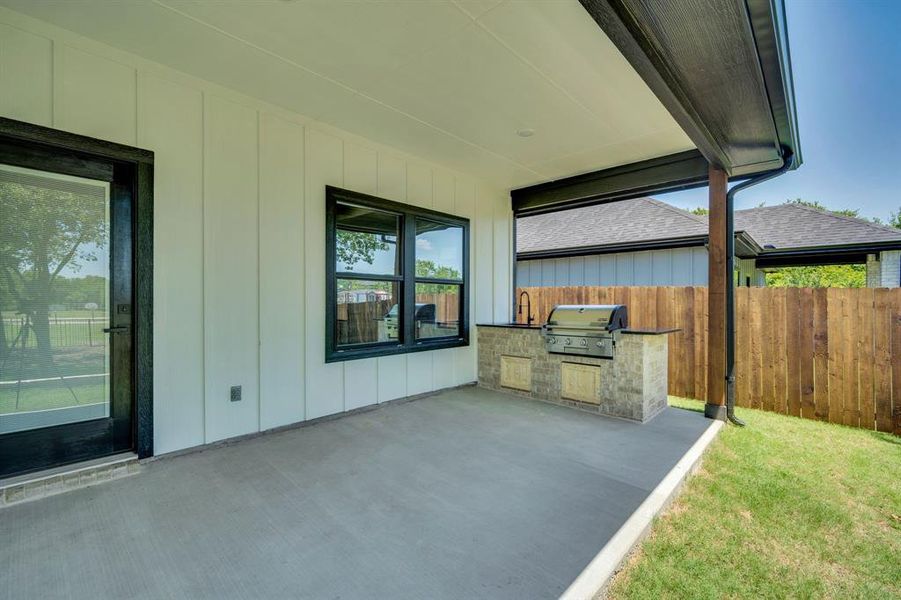 Large covered back patio with outdoor living cooking area.  Sink and propane grill perfect for family time and entertaining.