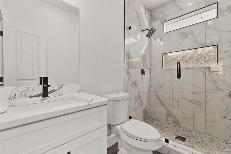 Full bath featuring vanity and a marble finish shower Full bath featuring vanity and a marble finish shower