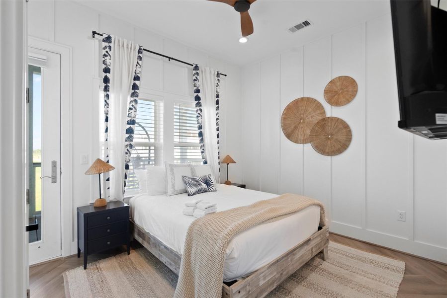 Nestled on the first floor, the third bedroom offers a peaceful coastal retreat with a refined touch. Calming hues, natural textures, and a plush bed set a relaxed atmosphere, complemented by a breezy side window and a sleek wall-mounted TV for added comfort. Enjoy direct access to the en suite bath, as well as a private door leading to the shared balcony—connecting effortlessly with the adjacent bedroom for seamless indoor-outdoor living. Nestled on the first floor, the third bedroom offers a peaceful coastal retreat with a refined touch. Calming hues, natural textures, and a plush bed set a relaxed atmosphere, complemented by a breezy side window and a sleek wall-mounted TV for added comfort. Enjoy direct access to the en suite bath, as well as a private door leading to the shared balcony—connecting effortlessly with the adjacent bedroom for seamless indoor-outdoor living.