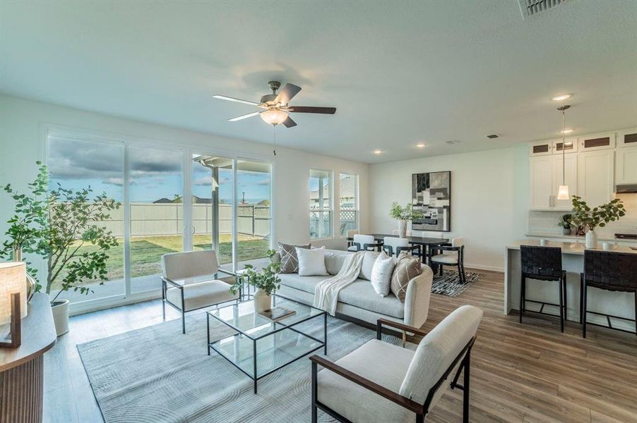 Living room with dark wood-type flooring, recessed lighting, and ceiling fan Living room with dark wood-type flooring, recessed lighting, and ceiling fan